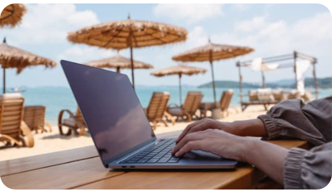 Photo of a digital nomad working on their laptop at the beach in Spain